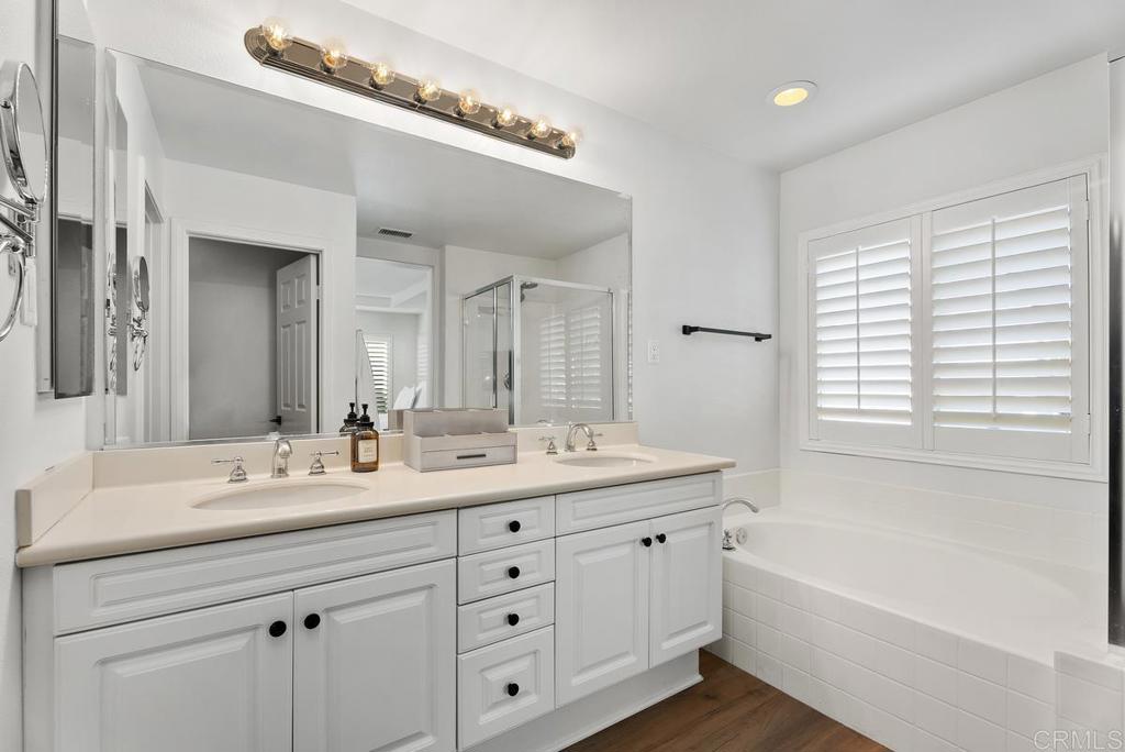 8 Potters Bend Ladera Ranch, CA 92694 - Photo 17 of 42 a bathroom with a double vanity sink a large mirror a bathtub and next to a window