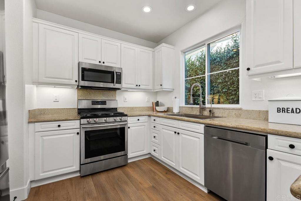 8 Potters Bend Ladera Ranch, CA 92694 - Photo 8 of 42 a kitchen with stainless steel appliances granite countertop a stove a sink and a microwave