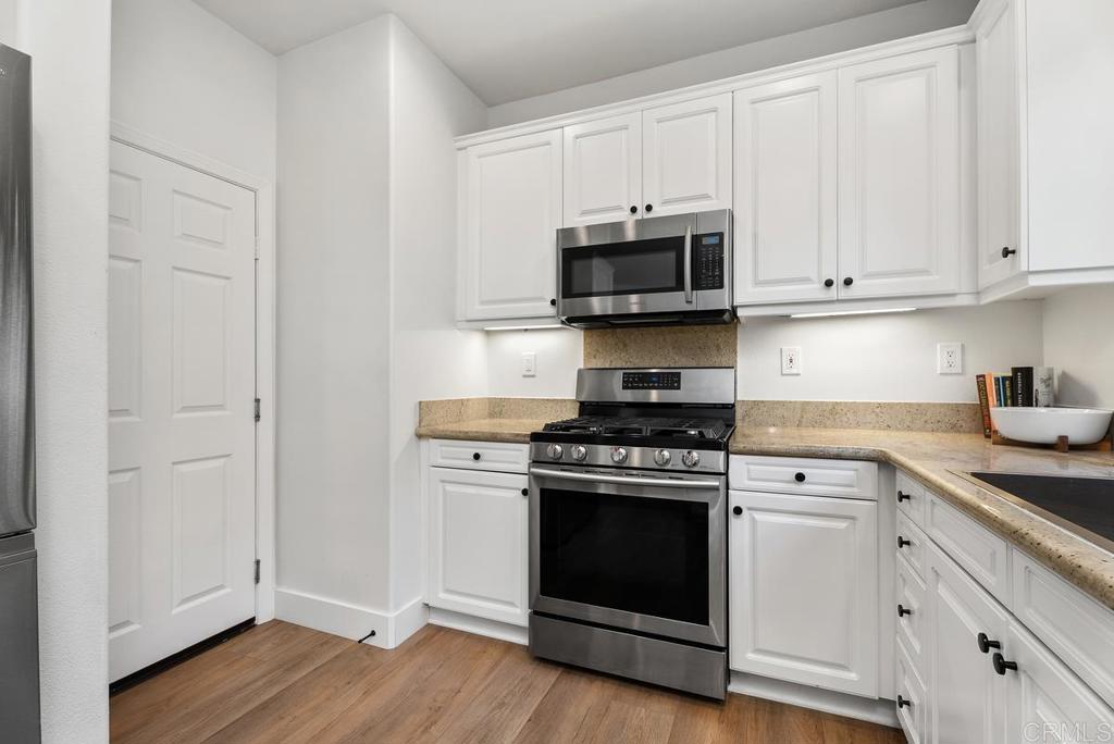 8 Potters Bend Ladera Ranch, CA 92694 - Photo 9 of 42 a kitchen with stainless steel appliances white cabinets and a stove top oven