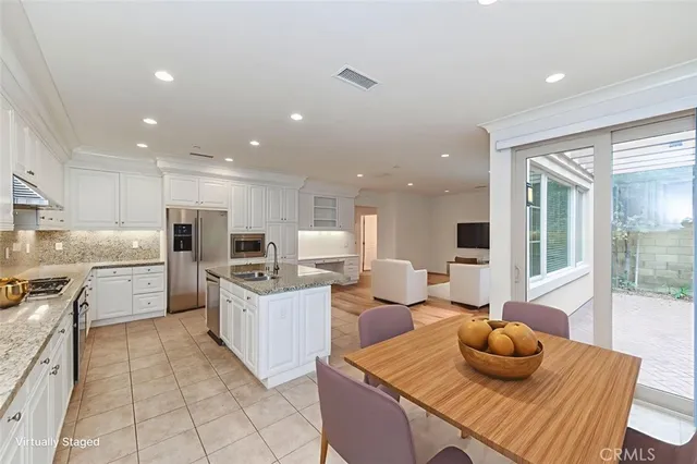 a kitchen with a sink white cabinets and stainless steel appliances