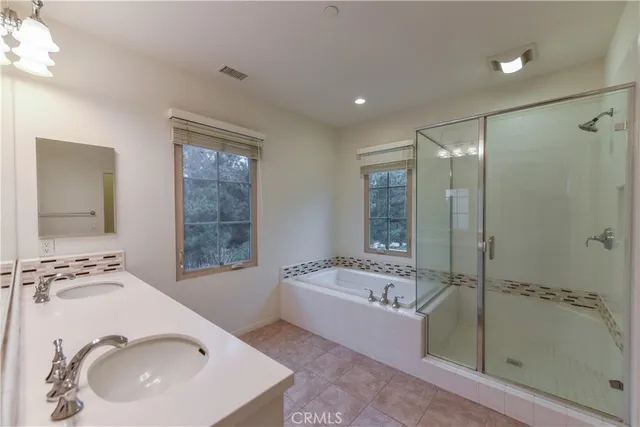 a bathroom with a tub sink and mirror
