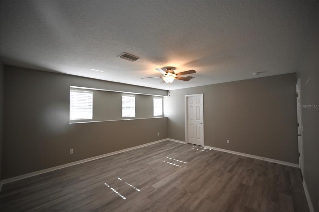 10922 Subtle Trail Drive Riverview, FL 33579 - Photo 18 of 60 wooden floor in an empty room with a window