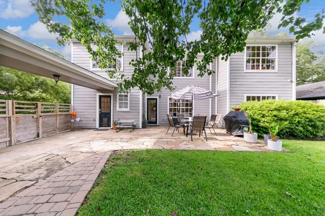 a view of a backyard with plants and large trees