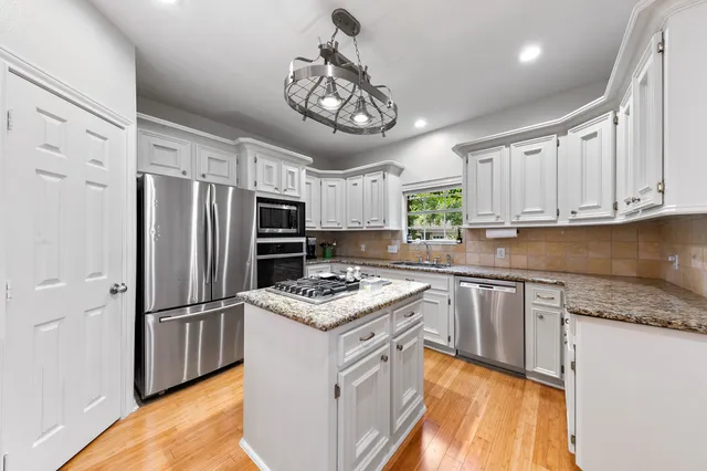 a view of a dining room and livingroom with furniture wooden floor a chandelier