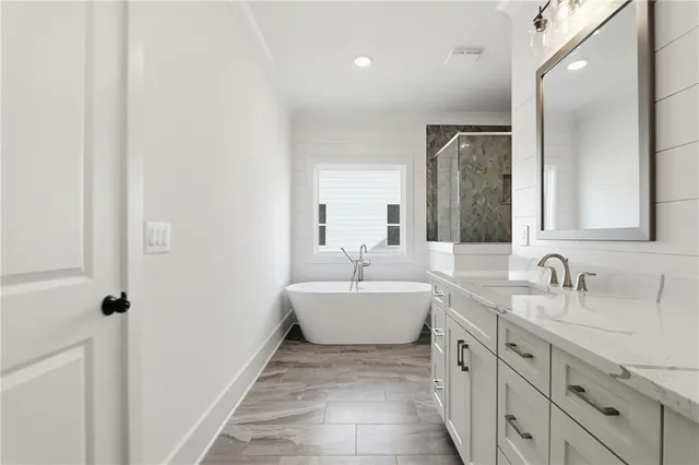 a bathroom with a double vanity sink mirror and bathtub