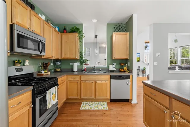 a kitchen with stainless steel appliances granite countertop a stove a sink and a microwave