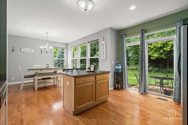 a dining hall with stainless steel appliances granite countertop a stove and a large window