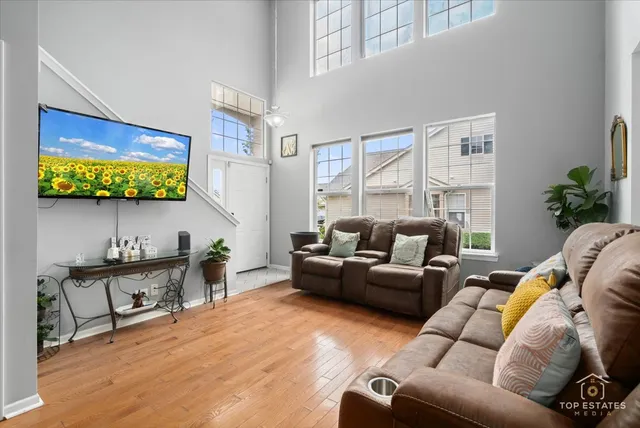 a living room with furniture a large window and a flat screen tv