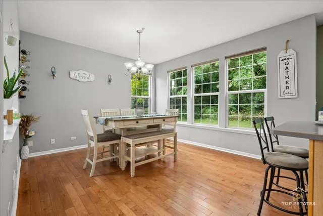 a dining room with furniture a chandelier and wooden floor