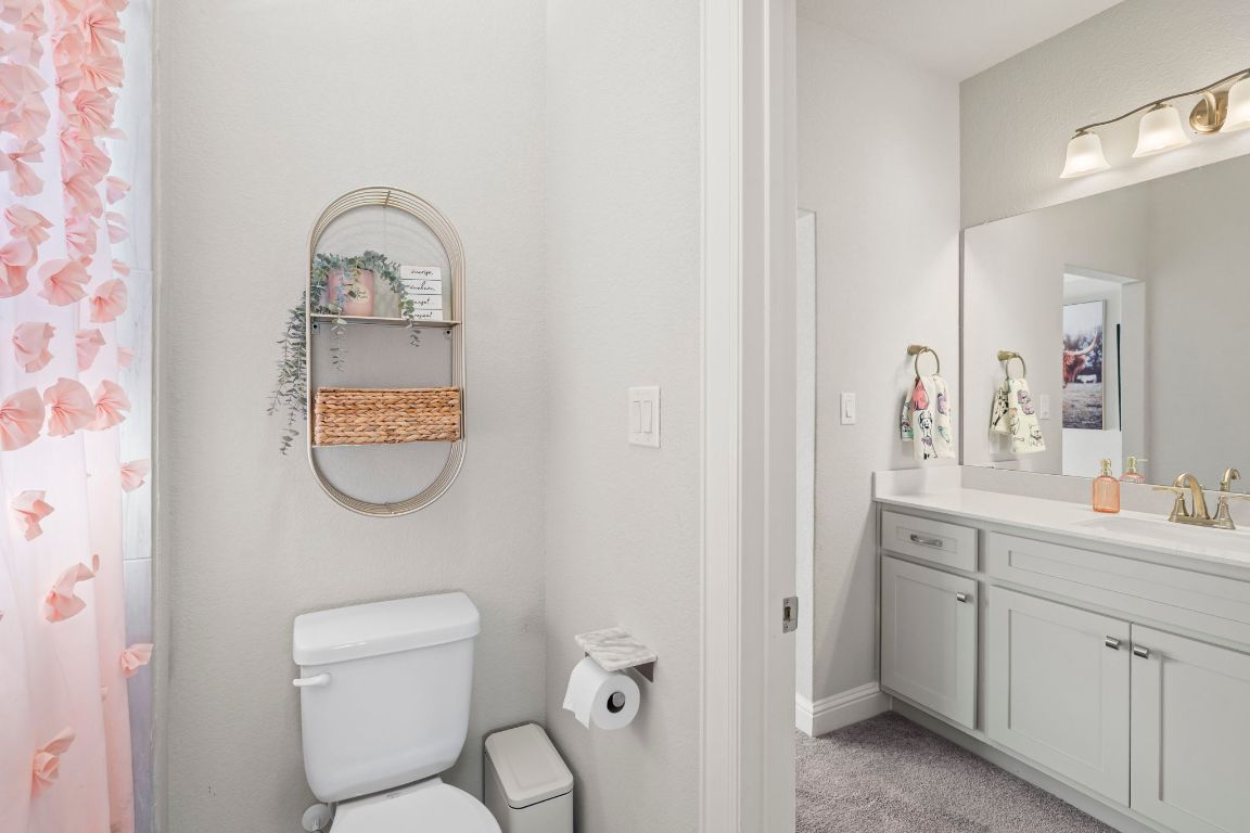 2605 Sam Bass Road, Unit 14 Round Rock, TX 78681 - Photo 21 of 30 a bathroom with a toilet a sink and mirror