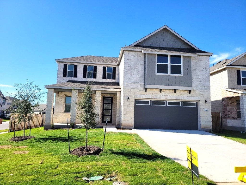 a front view of a house with a yard and trees