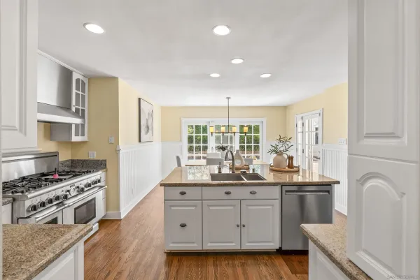 a kitchen with granite countertop a sink stove and cabinets
