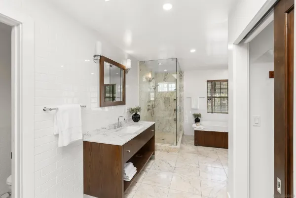 a bathroom with a tub sink shower and mirror