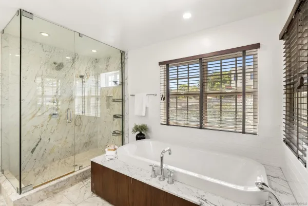 a bathroom with a granite countertop tub shower and sink
