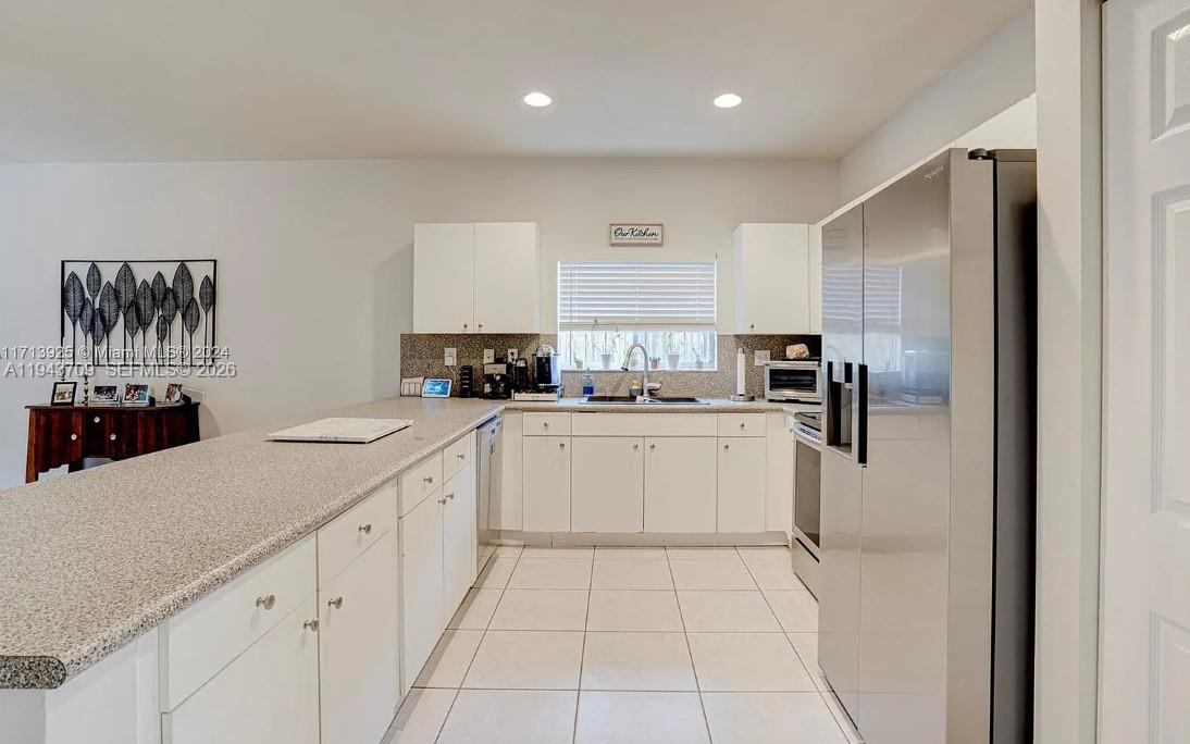 11410 Southwest 229th Terrace Miami, FL 33170 - Photo 19 of 36 a kitchen with white cabinets and refrigerator