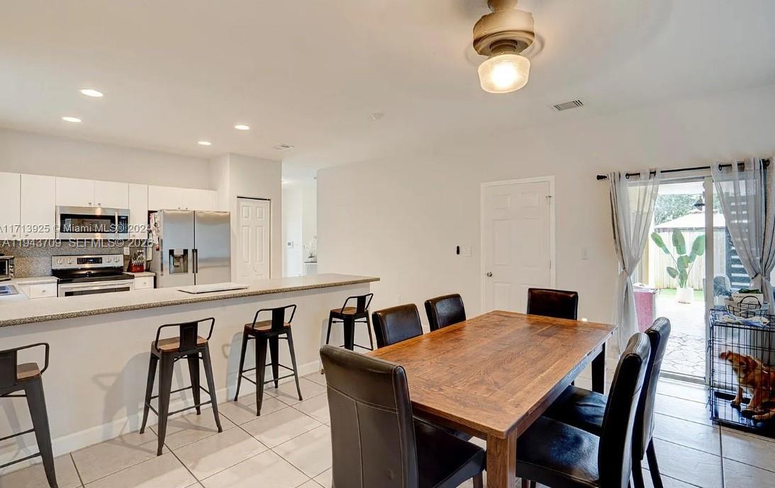 11410 Southwest 229th Terrace Miami, FL 33170 - Photo 23 of 36 a kitchen with cabinets table and chairs