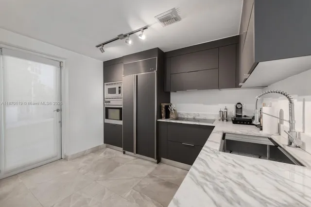 a kitchen with granite countertop a refrigerator and a sink