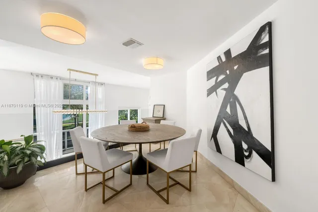 a view of a dining room with furniture and a potted plant