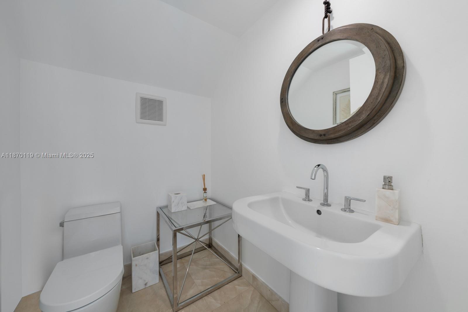 400 Alton Road, Unit TH1A Miami Beach, FL 33139 - Photo 15 of 45 a bathroom with a sink a toilet and a mirror