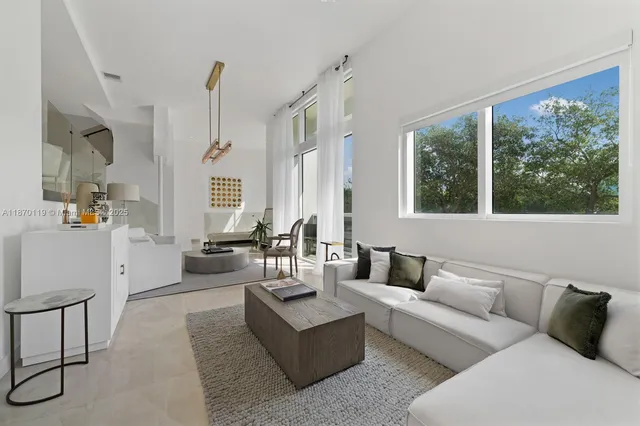 a living room with furniture and large windows