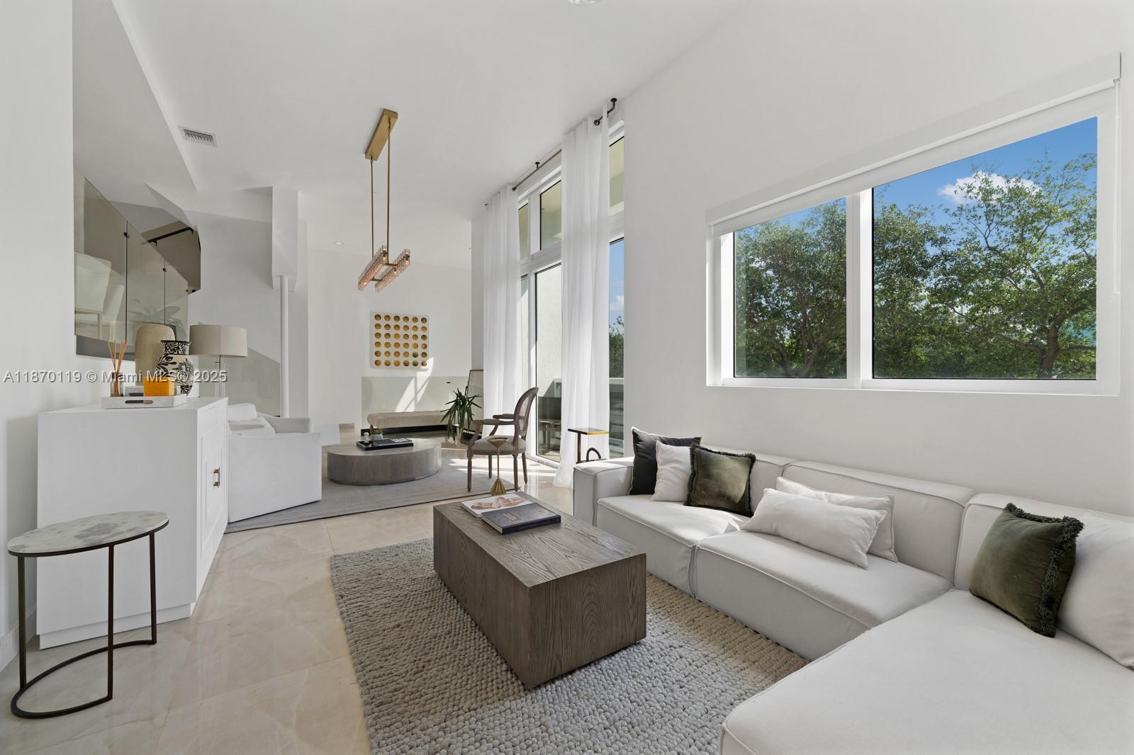 400 Alton Road, Unit TH1A Miami Beach, FL 33139 - Photo 2 of 45 a living room with furniture and large windows