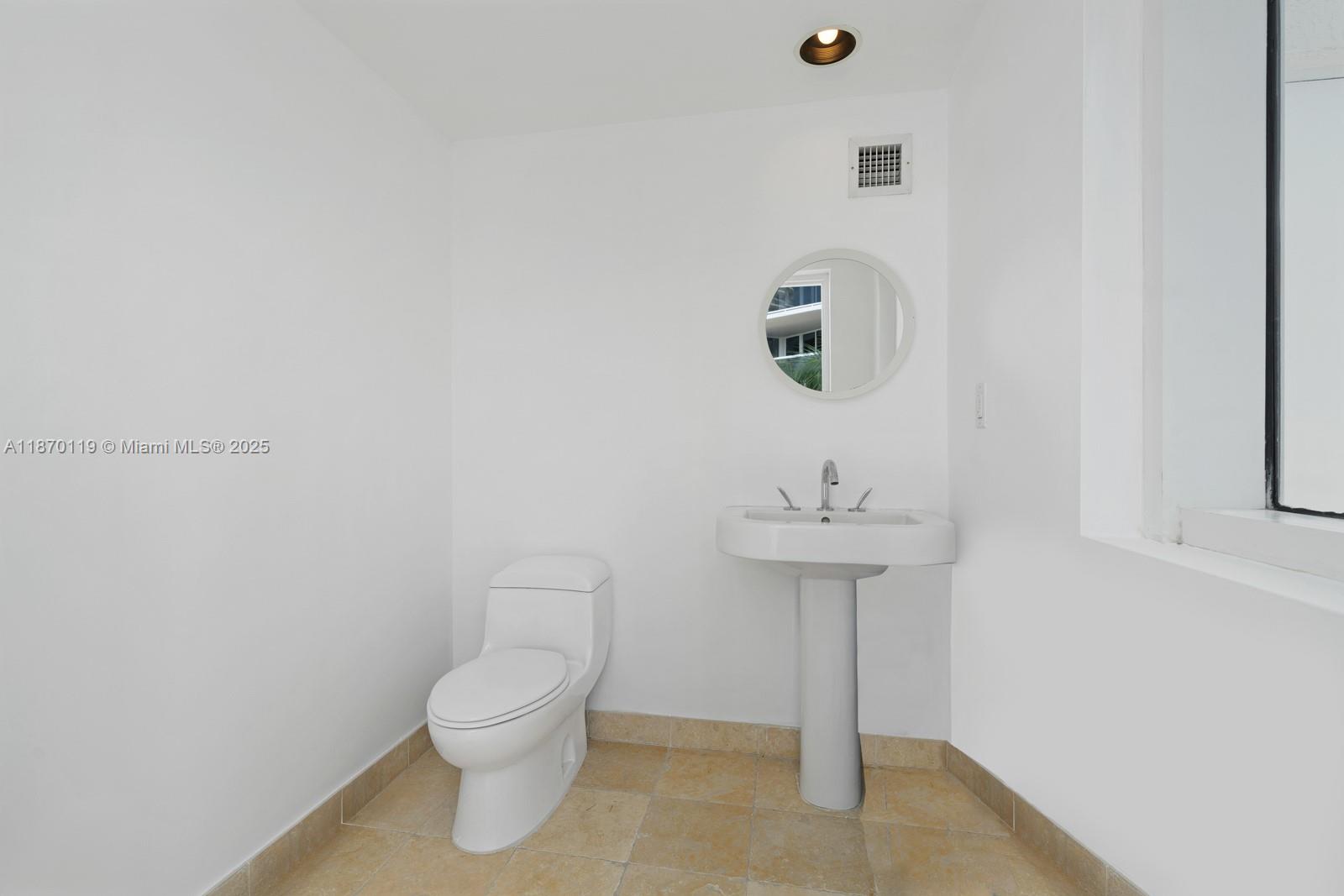 400 Alton Road, Unit TH1A Miami Beach, FL 33139 - Photo 31 of 45 a bathroom with a toilet a sink and mirror