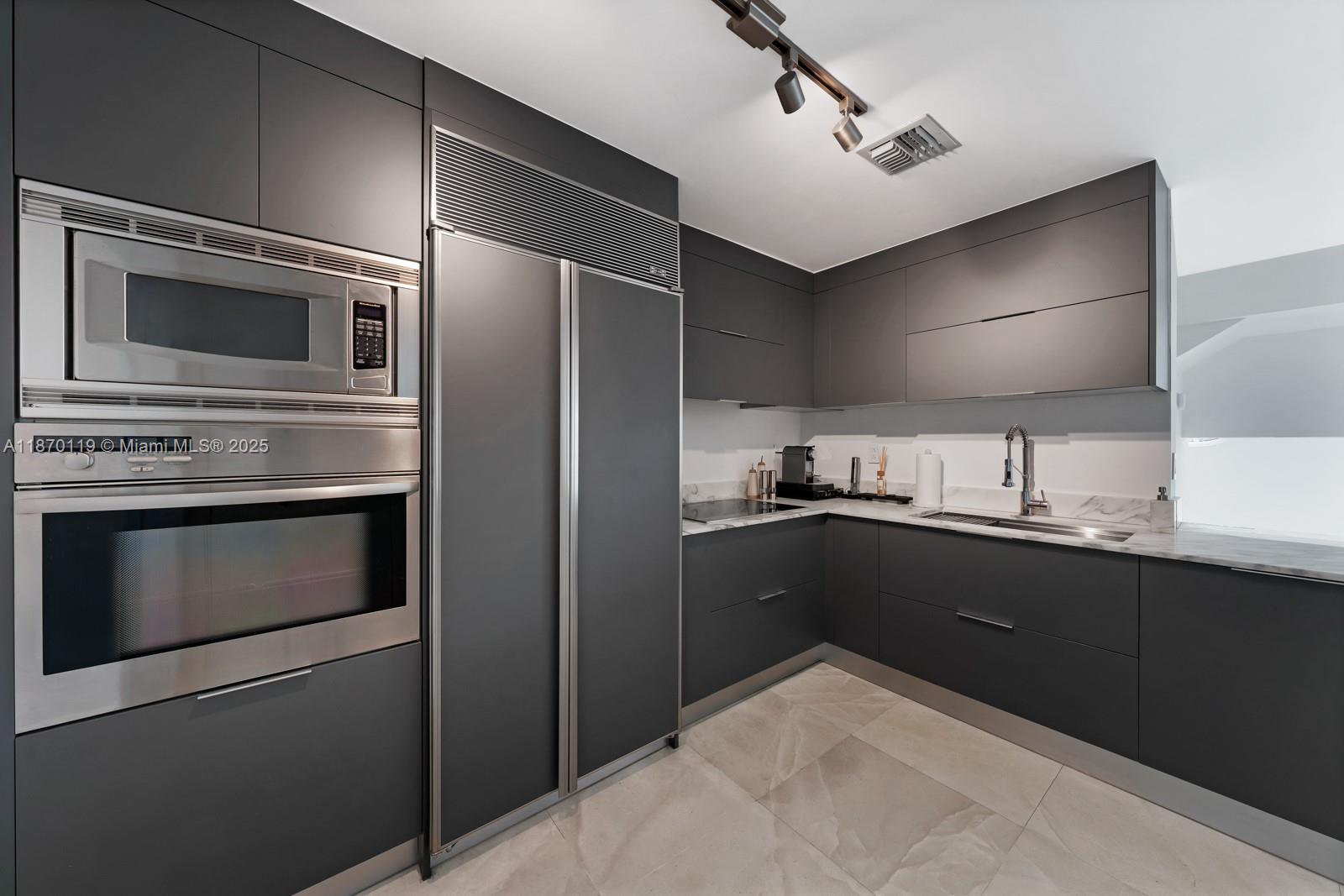 400 Alton Road, Unit TH1A Miami Beach, FL 33139 - Photo 10 of 45 a kitchen with stainless steel appliances kitchen island granite countertop a refrigerator stove and sink