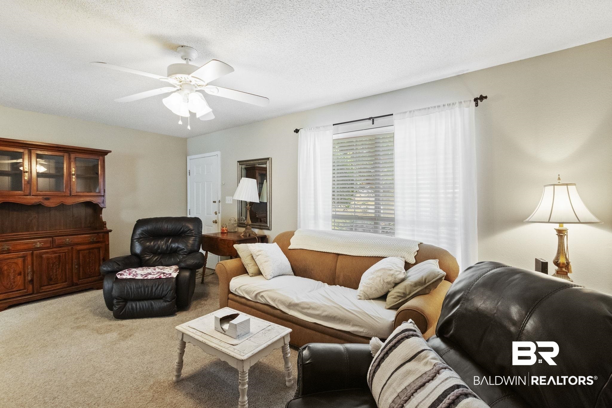 14031 Brook Hollow Road Summerdale, AL 36580 - Photo 14 of 56 Carpeted living room featuring ceiling fan and a textured ceiling