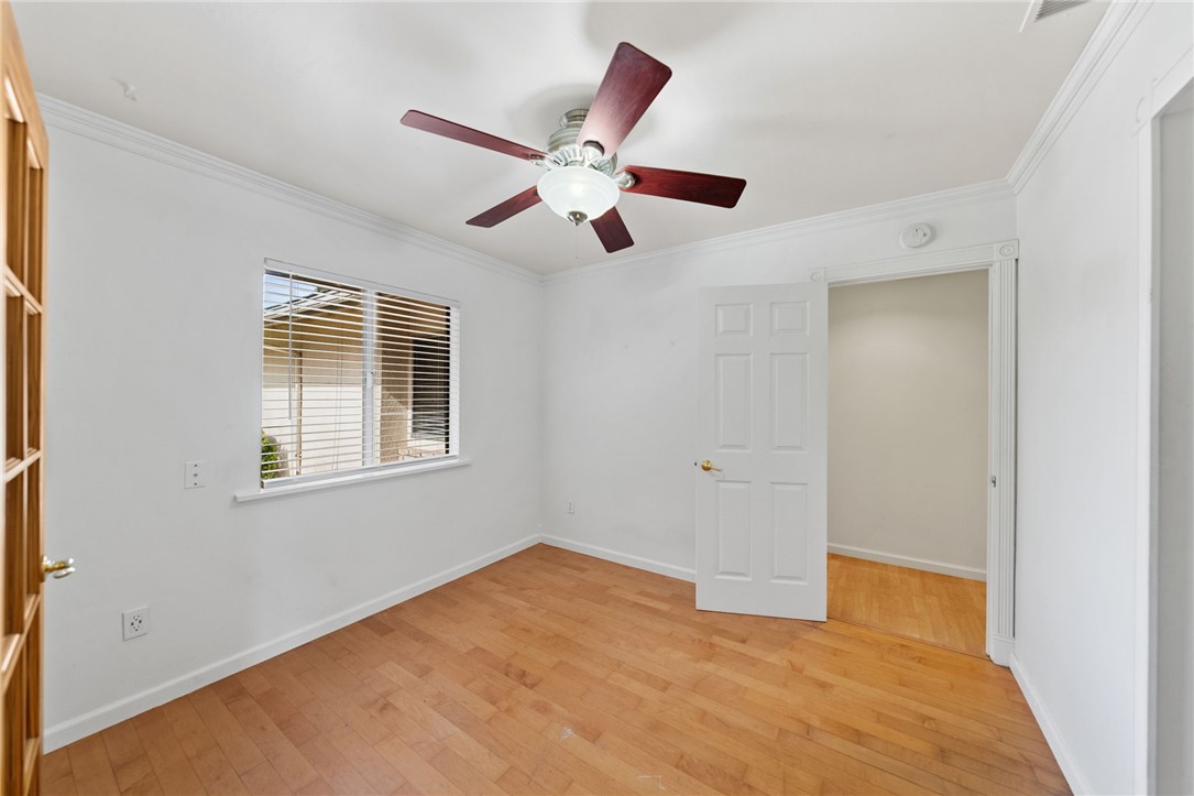 6090 Meadowbrook Lane Riverside, CA 92504 - Photo 18 of 37 Bedroom 1 with wood flooring, crown molding, and a ceiling fan, plus a window with blinds for natural light.