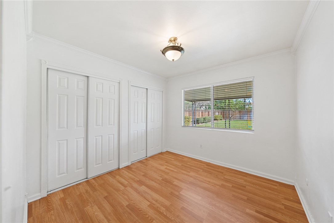6090 Meadowbrook Lane Riverside, CA 92504 - Photo 24 of 37 Bedroom 3 - Comfortable secondary bedroom with dual closets, wood flooring, and a backyard-facing window.