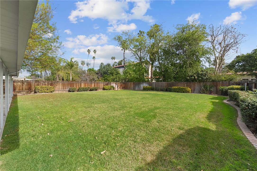 6090 Meadowbrook Lane Riverside, CA 92504 - Photo 29 of 37 Spacious, level lawn with mature trees and a fully fenced yard—ideal for outdoor living and play.