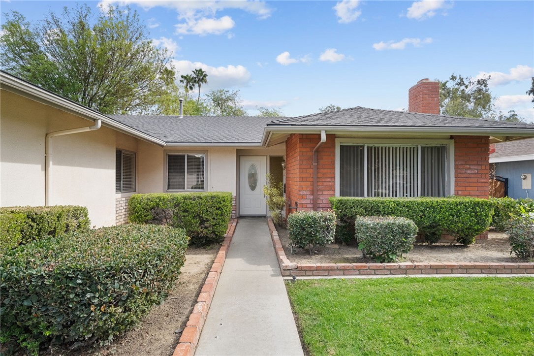 6090 Meadowbrook Lane Riverside, CA 92504 - Photo 10 of 37 Defined walkway to the front door with tidy planters and well-maintained hedges for a welcoming approach.