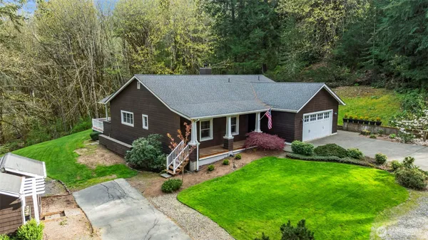 a aerial view of a house with a big yard plants and large tree