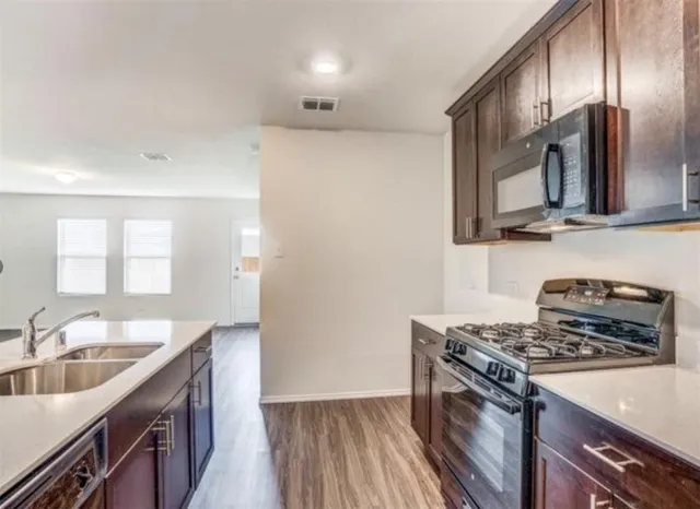 a kitchen with stainless steel appliances granite countertop a sink stove and refrigerator