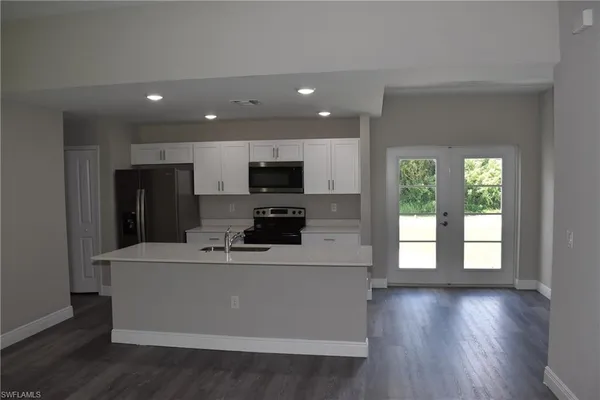 a kitchen with kitchen island stainless steel appliances a sink a stove a microwave and cabinets