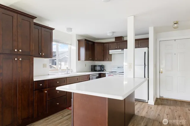 a kitchen with a sink a stove a refrigerator and cabinets