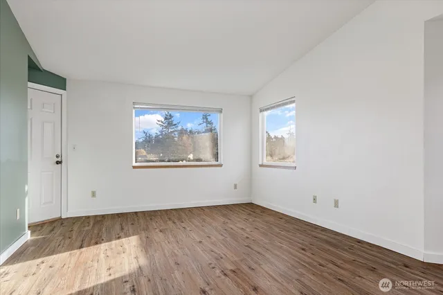 an empty room with wooden floor and window