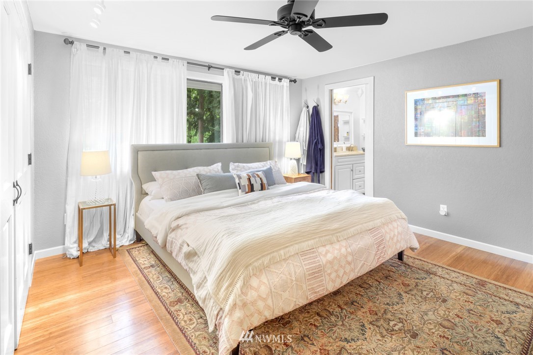 3853 Magrath Road Bellingham, WA 98226 - Photo 19 of 40 a bedroom with a large bed and a chandelier