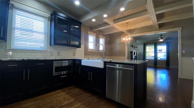 a kitchen with stainless steel appliances granite countertop wooden cabinets a sink and dishwasher