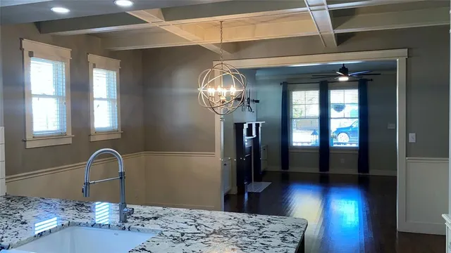 a view of a hallway with wooden floor and a chandelier