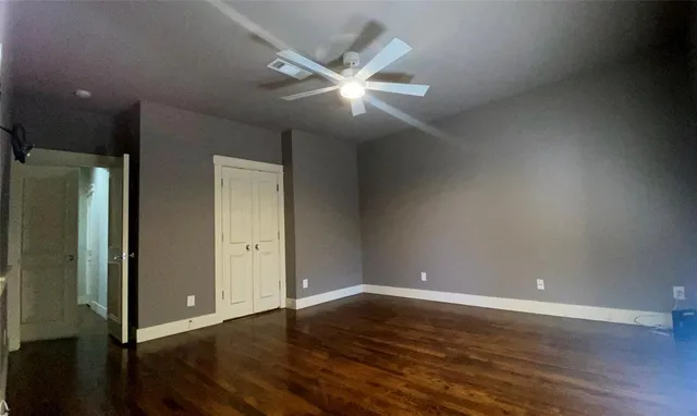 an empty room with wooden floor and closet