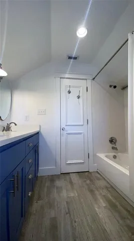 a bathroom with a tub sink and mirror