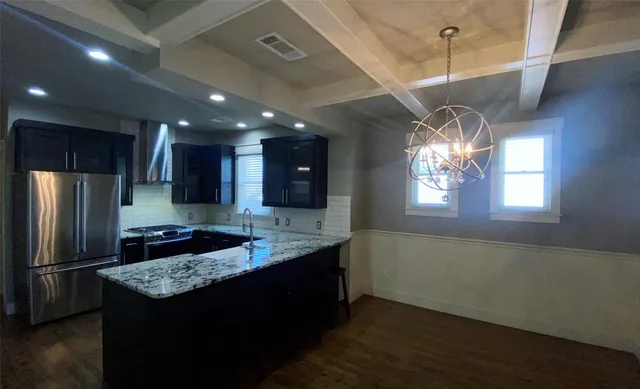 a kitchen with kitchen island granite countertop stainless steel appliances a sink stove and refrigerator