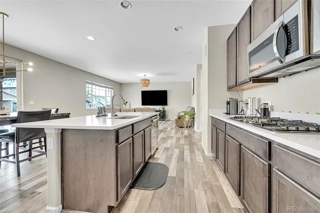 a kitchen with stainless steel appliances kitchen island granite countertop a stove a sink and a refrigerator