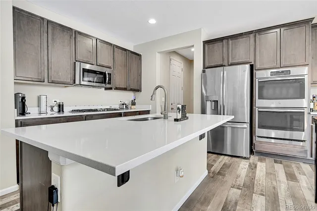 a kitchen with stainless steel appliances a refrigerator sink and microwave