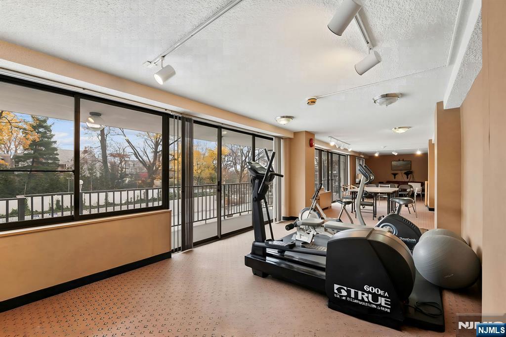 277 Prospect Avenue, Unit 11H Hackensack, NJ 07601 - Photo 17 of 23 a room with gym equipment and large windows