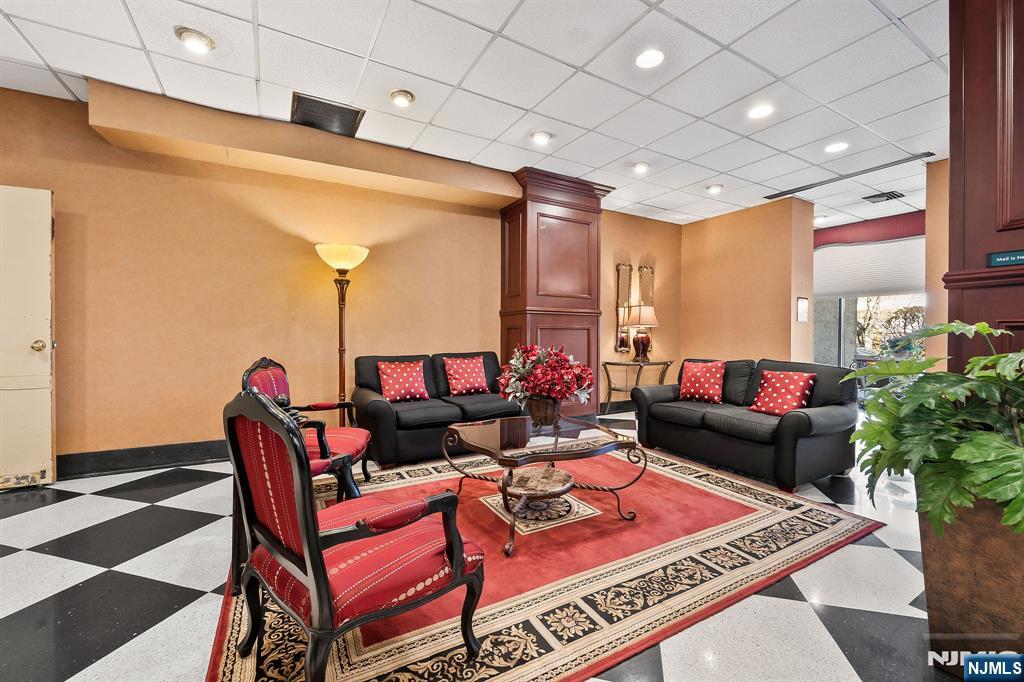 277 Prospect Avenue, Unit 11H Hackensack, NJ 07601 - Photo 6 of 23 a living room with furniture a rug and a chandelier