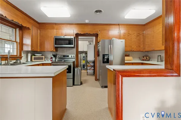 a kitchen with stainless steel appliances granite countertop a refrigerator a stove and a sink with wooden cabinets