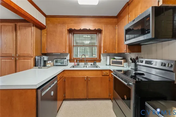 a kitchen with stainless steel appliances a sink a stove top oven a counter space and cabinets