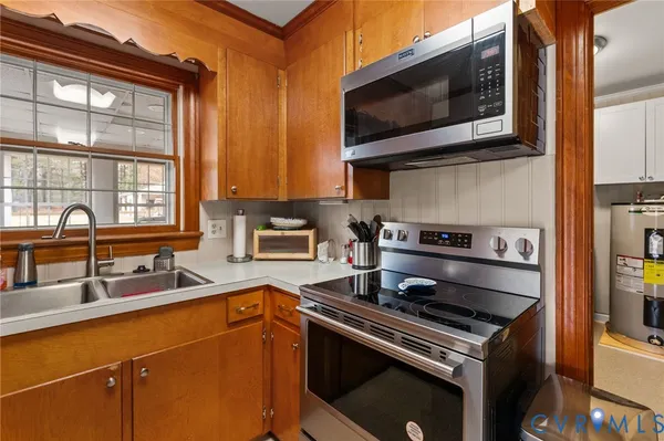 a kitchen with stainless steel appliances a stove a sink and a microwave